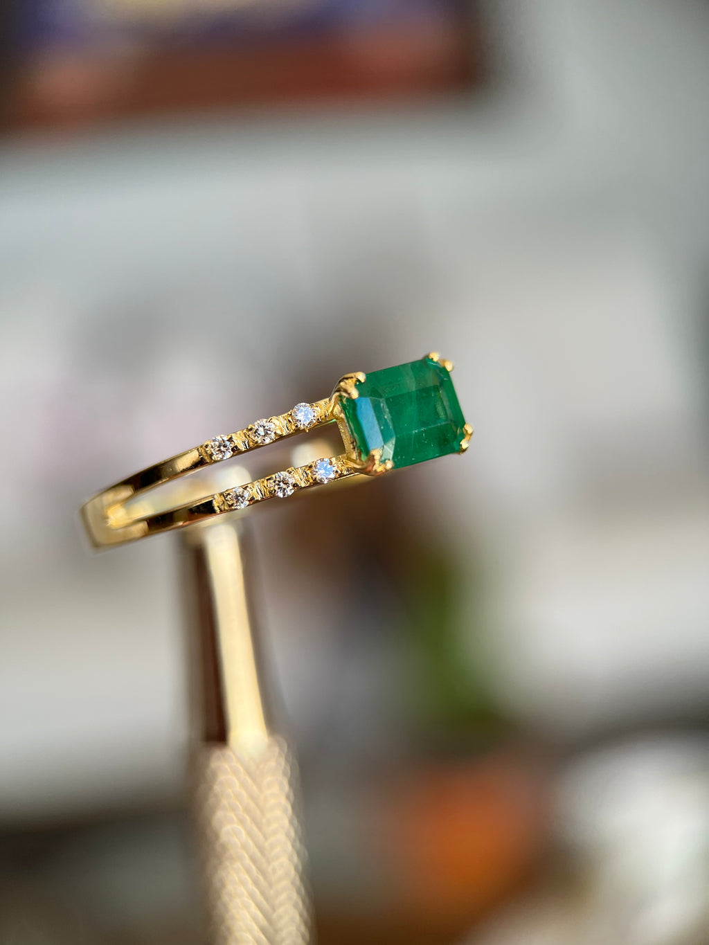 Anel duas fileiras de diamantes com esmeralda retangular
