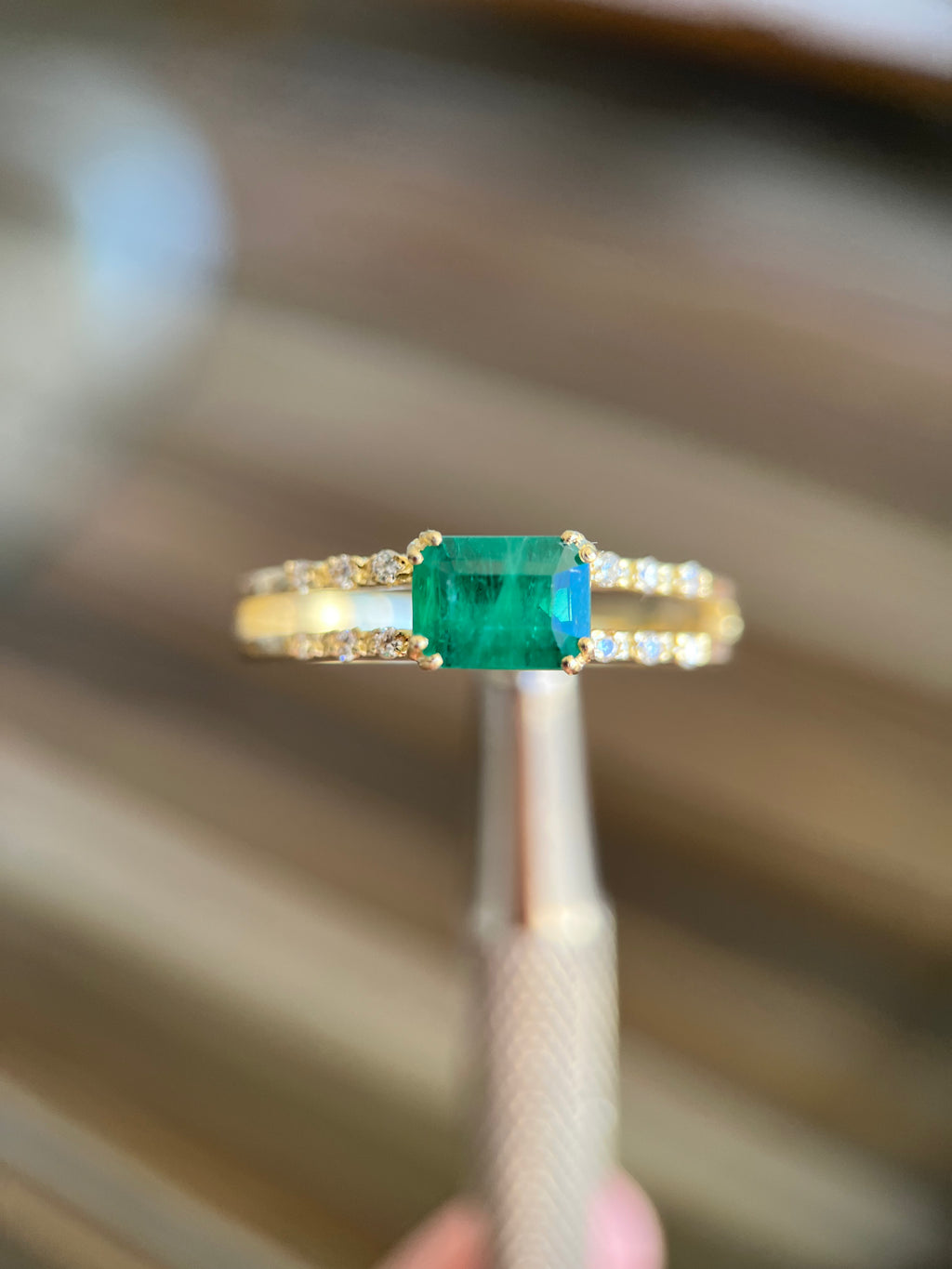 Anel duas fileiras de diamantes com esmeralda retangular