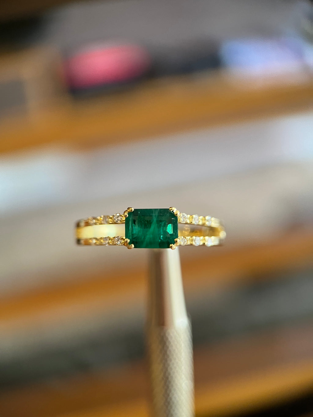 Anel duas fileiras de diamantes com esmeralda retangular