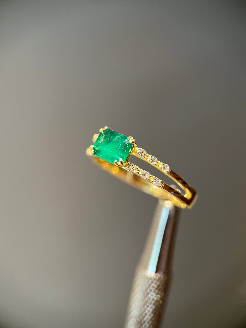 Anel duas fileiras de diamantes com esmeralda retangular